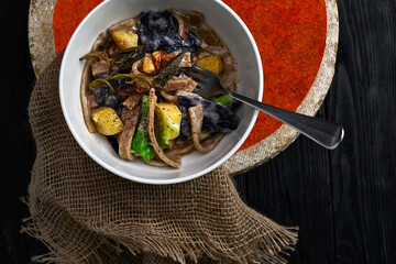 pasta pizzoccheri with chinese cabbage, potato on dark background. italian traditional dish
