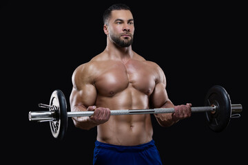 Fototapeta na wymiar Handsome fitness man is lifting a heavy barbell working over his biceps isolated on black background