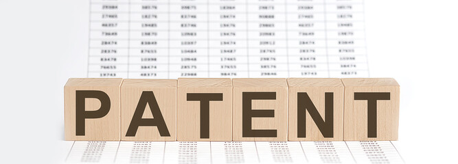 wooden cubes with letters PATENT on chart background