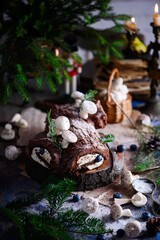 Fototapeta na wymiar YULE LOG CAKE on a Christmas rustic background