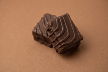 small square chocolate cake on color background