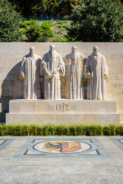 Front view of the four statues at the center of the Reformation Wall in the Parc des Bastions in Geneva, Switzerland, representing John Calvin and the Calvinism's main proponents, on a sunny day.
