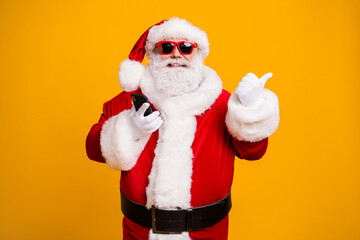 Portrait of his he nice attractive cheerful fat overweight bearded Santa using device showing copy space like follow subscribe isolated bright vivid shine vibrant yellow color background