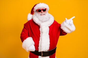 Portrait of his he nice attractive cheerful cheery fat Santa father demonstrating copy space advert newyear celebratory day isolated over bright vivid shine vibrant yellow color background