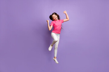 Fototapeta premium Full length body size photo of jumping high pretty schoolgirl with long brunette hair celebrating win cheering shouting loudly isolated on purple color background