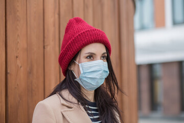 Young European womanin medical mask. At atumn city