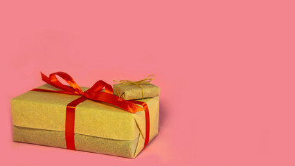 christmas handmade holiday concept congratulation, box with red bow with gifts, on pink background, new year. Wrapped vintage gift box with red ribbon bow