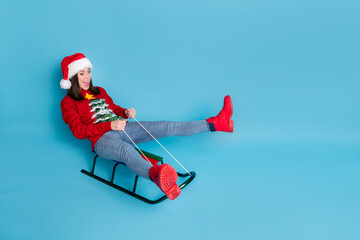 Photo portrait of woman riding sled screaming isolated on pastel light blue colored background