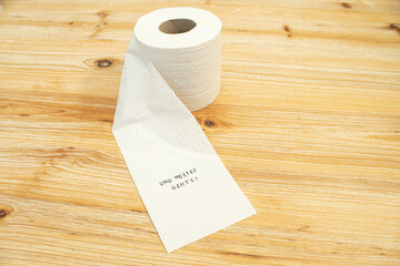 Toilettenpapier auf Holztisch mit Statement auf deutsch zu Berliner Entscheidung Entschluss