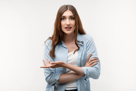 Portrait Of Good-looking Carefree Woman Shrugging With Spread Palm, Saying Sorry. Studio Shot, White Background