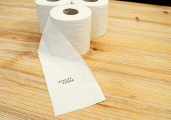 Toilettenpapier auf Holztisch mit Statement auf deutsch zu Berliner Entscheidung Entschluss