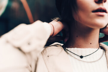 Close-up portrait Beautiful elegant woman wearing beige coat and black hat. Trendy casual outfit....