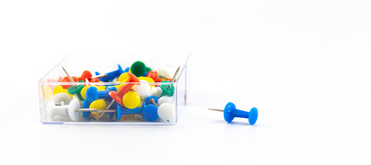 Stationery multicolored pins in a box on a white isolated background