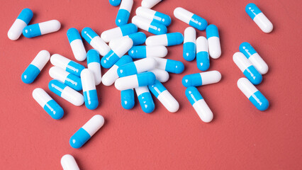white and blue pills on red background