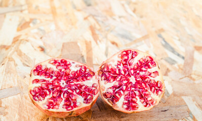 Pomegranate open in half on top of a organic background with copy space. Autumn or winter seasonal fruit. Healthy superfood rich in vitamin C.