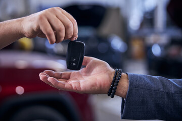 Mechanic handing man modern electronic car key