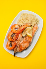 fried salmon with shrimps and cous-cous on white dish