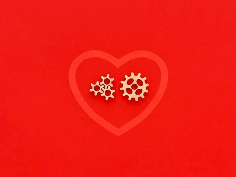 wooden gears in heart, symbol on the red background, concept
