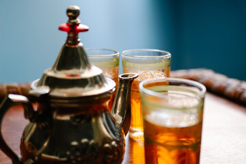 horizontal image of near a metal teapot with three Arabian glass cups