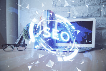 Multi exposure of table with computer and seo drawing hologram. Search optimization concept.