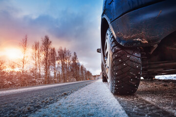 Car tires on winter road covered with snow