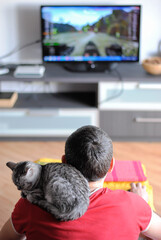 Kitten sits on the shoulder of a male gamer