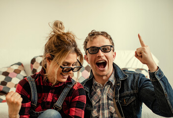 Smiling lovely young couple relaxing and watching TV at home. Love couple. Man and woman home concept. Photo. Fun. Sofa. 
