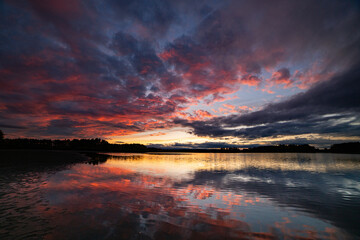 wide amazing dawn colorful sunset above the water