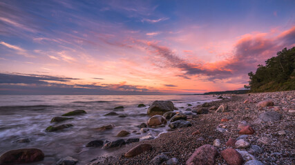 Colorful sunset over the sea and rocky shore