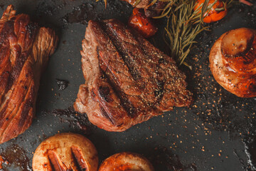 Grilled steak with rosemary tomatoes and mushrooms, view from above