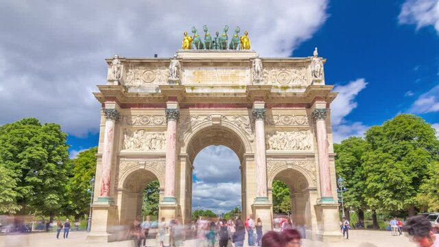 Triumphal Arch (Arc de Triomphe du Carrousel) timelapse hyperlapse at Tuileries gardens in Paris, France. Tourist walking around at summer day with blue cloudy sky.