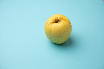 yellow apple on blue background