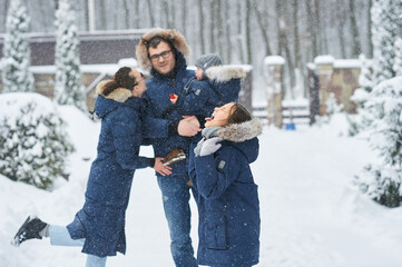 Obraz premium Happy family have a fun outside near the house in winter