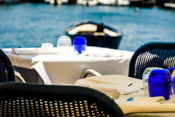 Elegant lunch restaurant, overlooking the sea and boats. Restaurant tables prepared waiting for customers, stock photo