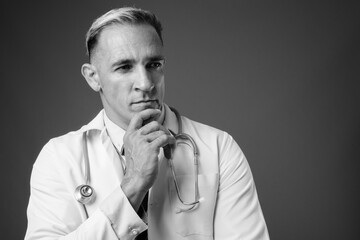Face of man doctor against gray background