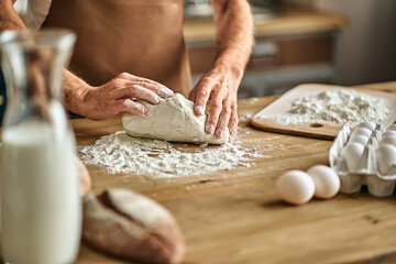 Chef kneading dough for baking in the kitchen