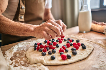 Obraz na płótnie Canvas Chef preparing sweet pastries with fresh berries