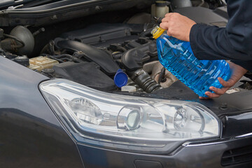 Man pours winter non-freezing liquid into car washer tank