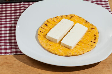 Tasty traditional breakfast in Colombia; Arepa of yellow corn with cheese.