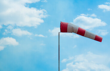 striped windsock at the airport on the background of beautiful clouds