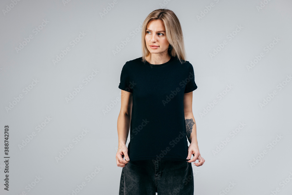 Sticker Stylish blonde girl wearing black t-shirt posing in studio