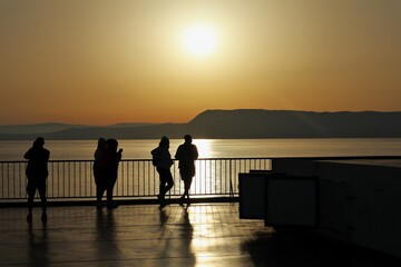 Fototapeta premium Turisti in viaggio sul traghetto all'alba