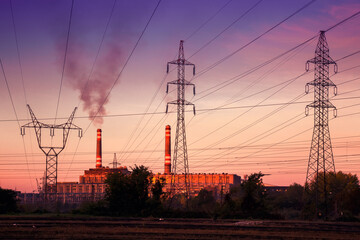 Fototapeta premium Power station with smoking chimney among electric wires