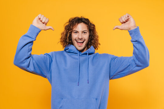 Cheerful young man posing isolated over yellow