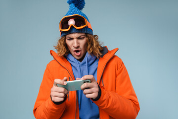 Man wearing winter jacket holding mobile phone