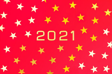 Numbers 2021 among gold yellow and white five-pointed stars on a red background. New Year postcard. Flatly, top view