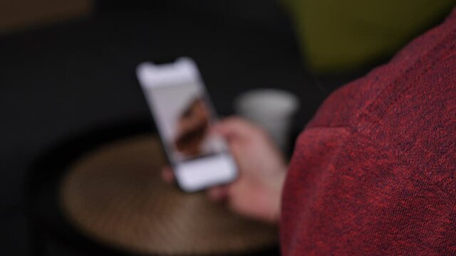 Close up shot of person swiping on tinder app on smartphone.Out of focus view.