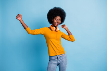 Photo portrait of pretty black skinned girl wearing headphones dancing at disco isolated on vibrant blue color background