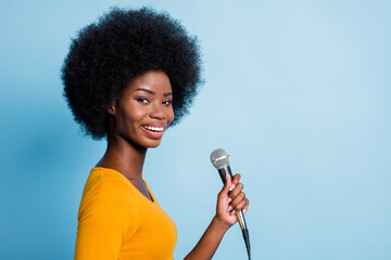 Photo side profile portrait of pretty black skinned girl keeping microphone smiling isolated on...