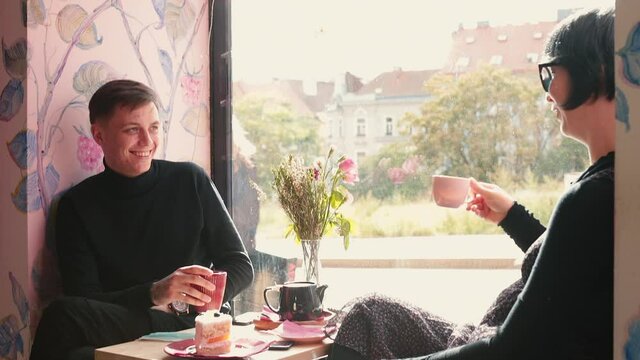 A couple at a large window of a cafe has a cute conversation. Online dating is the most popular way couples meet. The worst dating etiquette mistakes people usually make. 